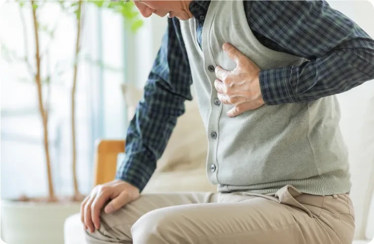 Man clutching chest possible chest pain Man clutching chest, showing signs of possible chest pain